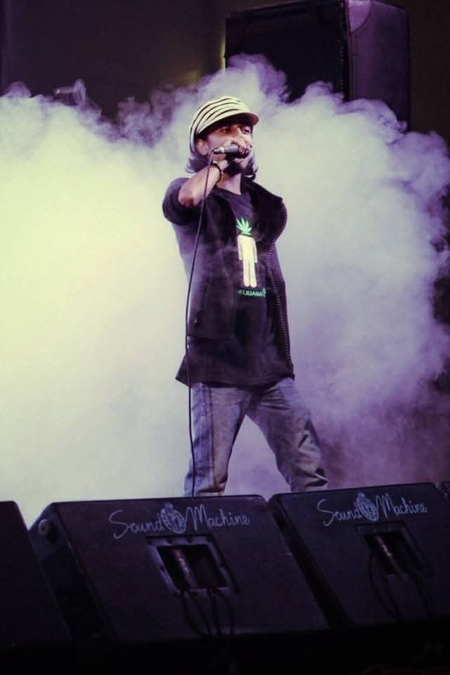 Nizam Rabby performing live on stage with smoke effects